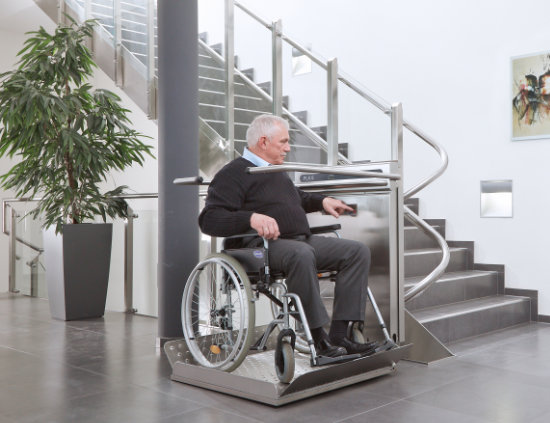 Inva Stair Riser in silver with a male wheelchair user using it.