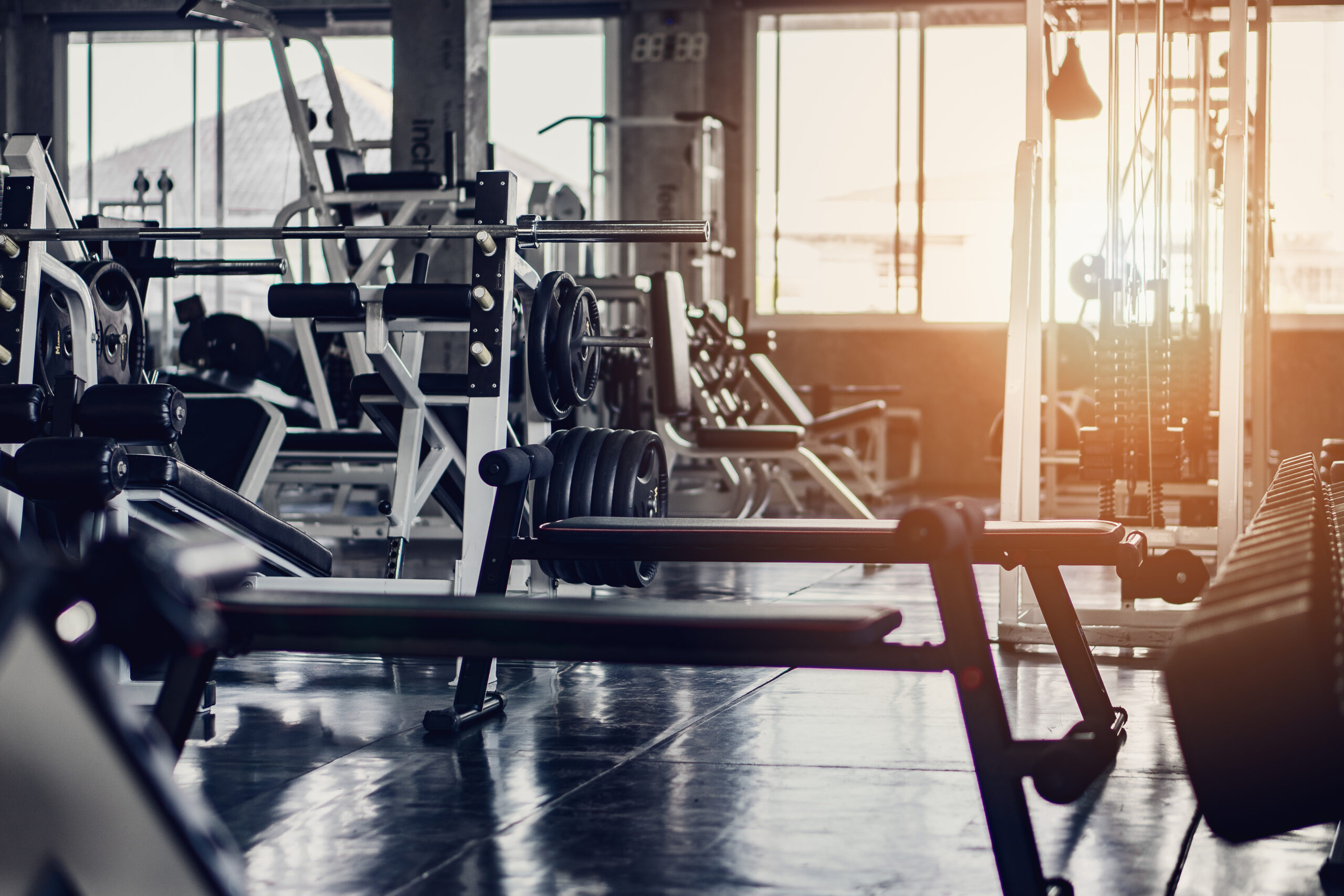 interior background of room in gym or fitness center fully equip of bodybuilding equipments and machines